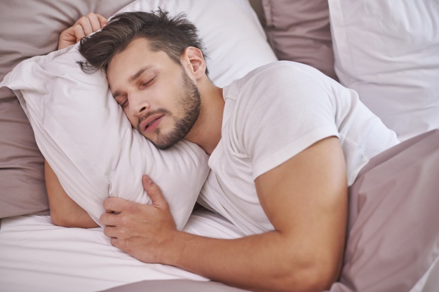 exhausted-man-sleeping-his-bed_329181-3282